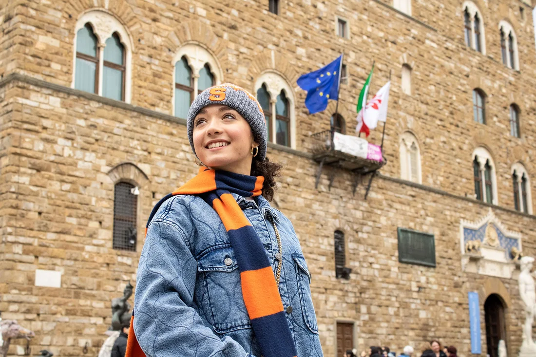 Student wearing Syracuse University scarf outside of a building in Florence.