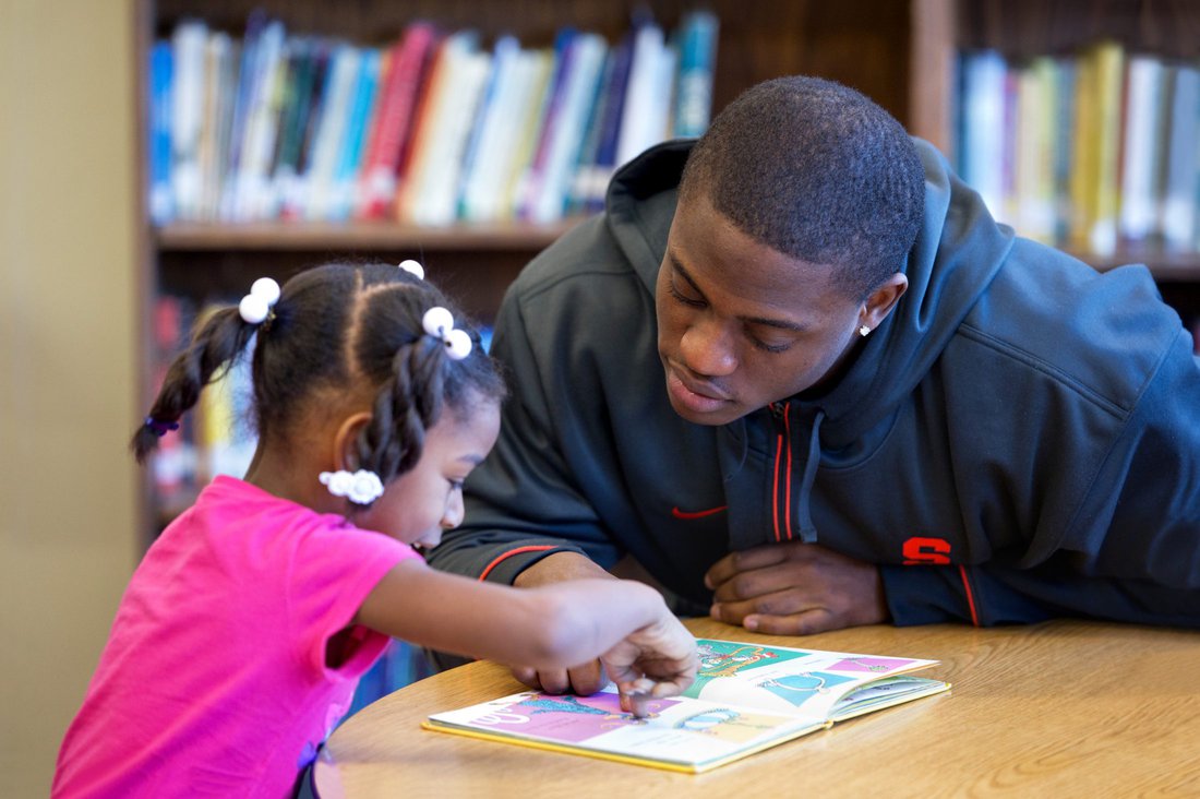 Syracuse student reading to elementary school student
