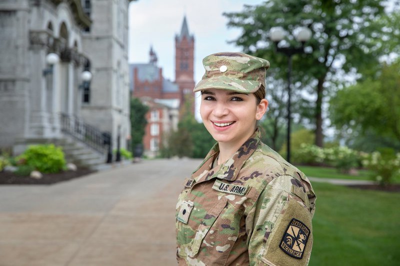 Madeline Messare poses for photo in ROTC uniform out front of the hall of languages
