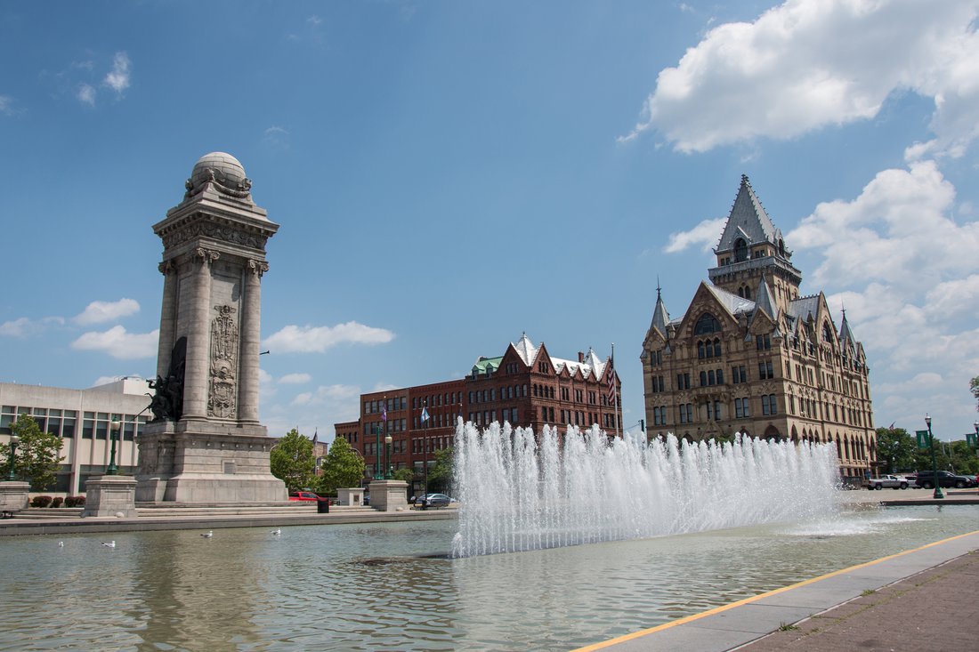 A fountain in summer in front of historical buildings in Clinton Square