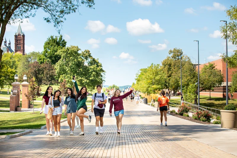 Students walk on the Einhorn Walkway on campus on a summer day.